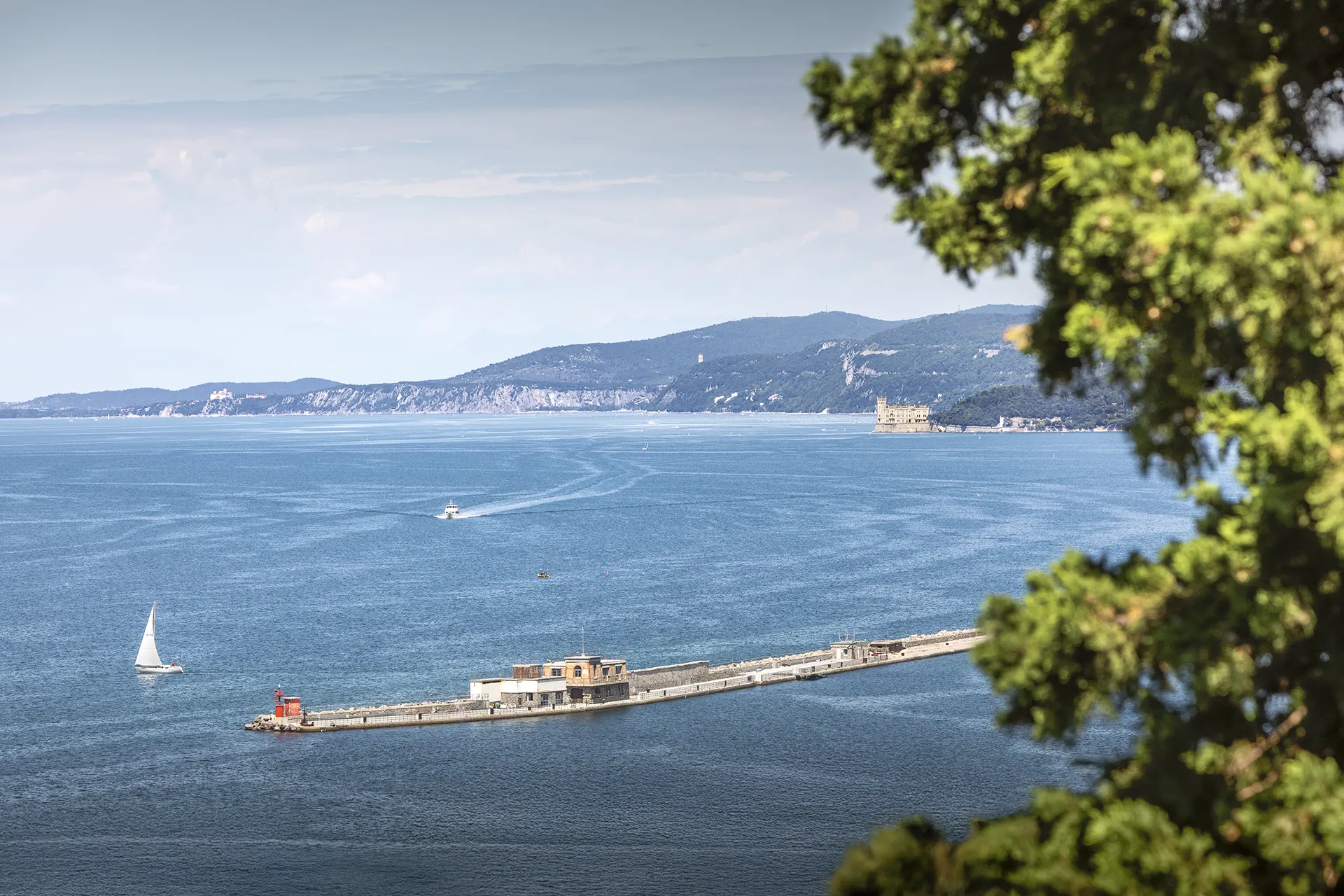 veduta panoramica mare triesVista panoramica dal punto panoramico di via Capitolina sul Golfo di Trieste, con il molo di contenimento e il Castello di Miramare sullo sfondote