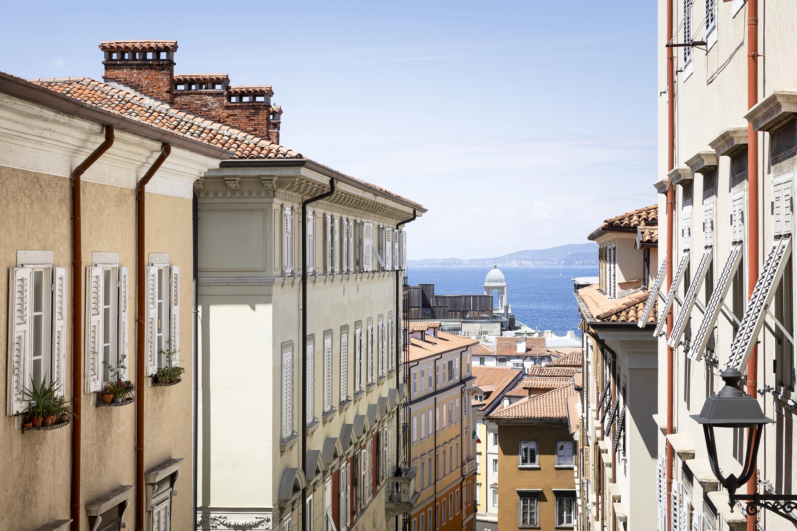 Via Giacomo Ciamician a Trieste con vista sul mare e sul Salone degli Incanti, tra palazzi storici, tetti in coppi e scorci del centro cittadino