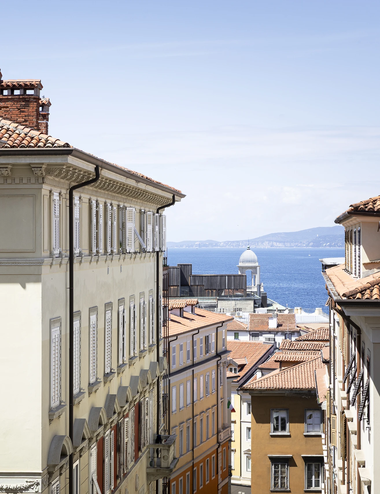 Via Giacomo Ciamician a Trieste con vista sul mare e sul Salone degli Incanti, tra palazzi storici, tetti in coppi e scorci del centro cittadino